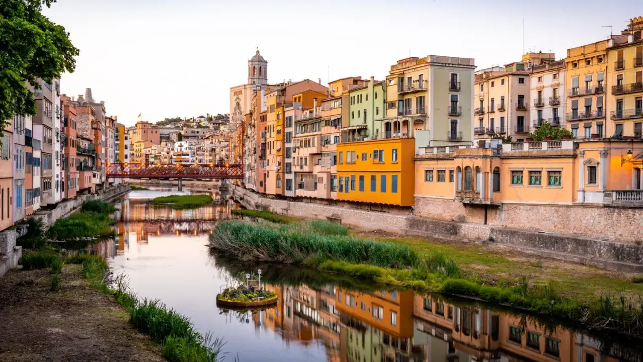 Kolorowe kamienice nad rzeką, idealna pogoda na Costa Brava w październiku.