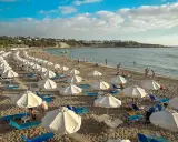 Piękna plaża na Cyprze, gdzie cypr pogoda w listopadzie pozwala na relaks pod białymi parasolami.
