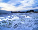 Błękitne niebo nad tarasami Pamukkale. Woda w basenach jest zimna, co może sugerować, czy w Turcji jest zima.